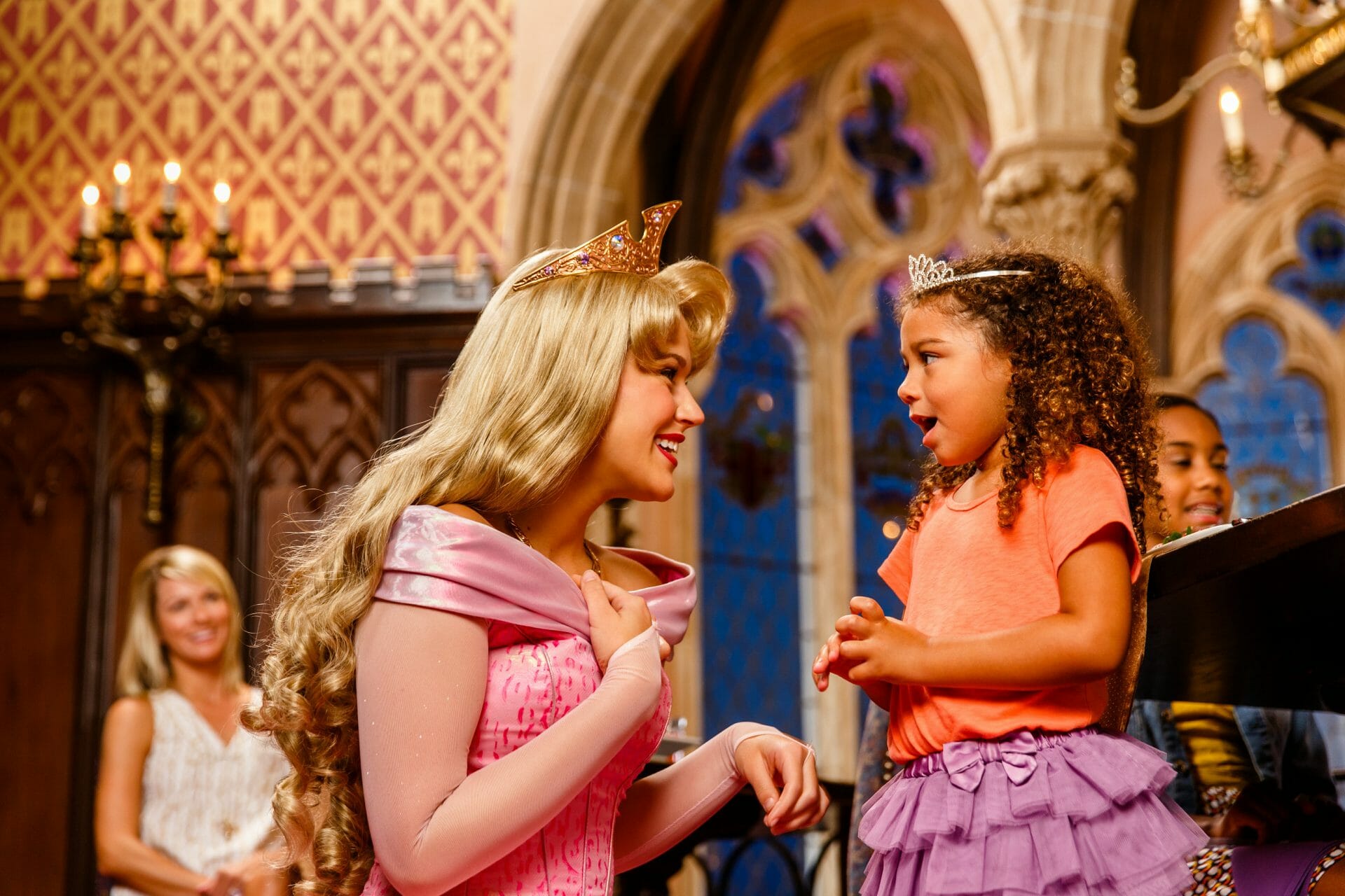 Disney princess cast member kneeling down to smile at child