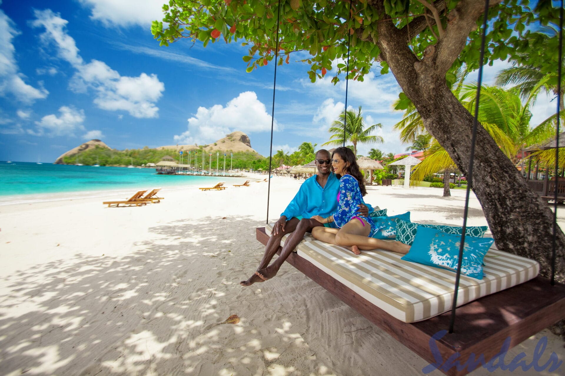 Couple siting on a swing near a beach in the Caribbean