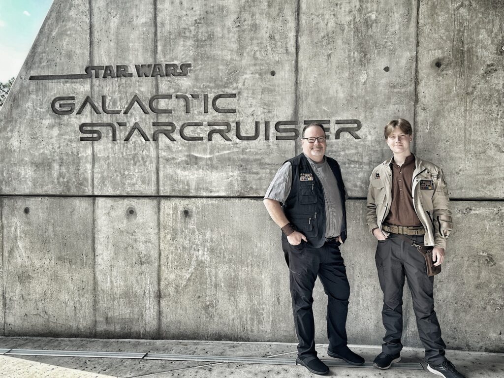Jeff and Wyatt in star wars garb in front of the entrance sign to Star Wars:Galactic Starcruiser