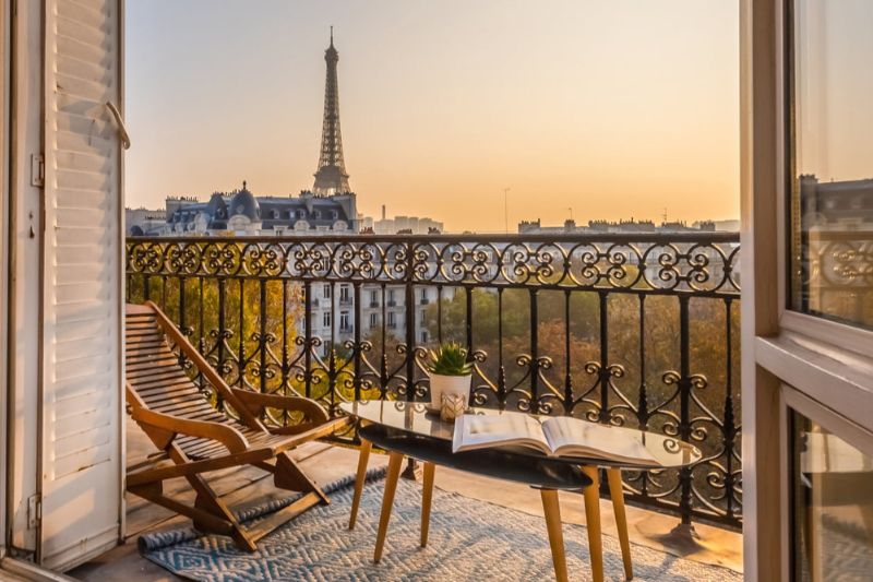 Balcony in Paris with a table and two chairs overlooking the Eiffel Tower