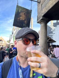 man drinking cider in front of Hogs Head Tavern,Wizarding World of Harry Potter,Hogsmeade Village,Islands of Adventure