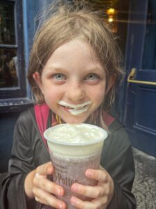 Girl holding butterbeer with butterbeer moustache, Diagon Alley, Wizarding World of Harry Potter, Universal Studios Orlando