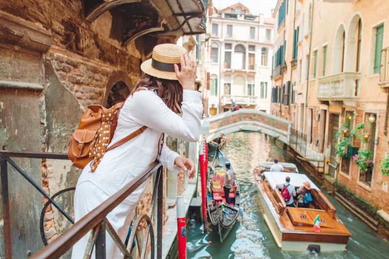 Woman looking over a gondola in Venice, Italy