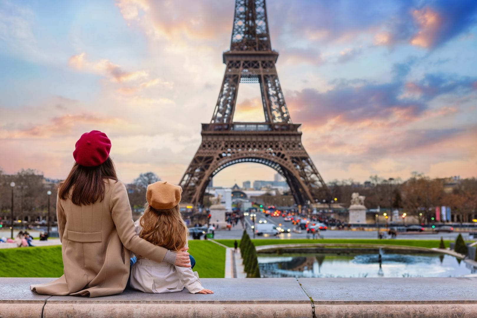 Sceptre Vacations. A mother and her daughter looking at the sunset view of the Eiffel Tower.